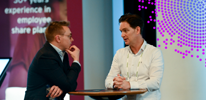 two men speaking at an exhibition stand